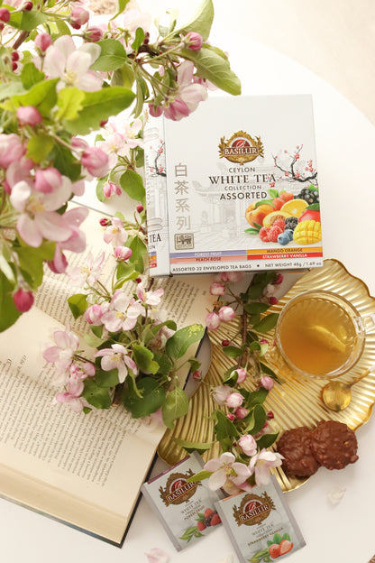 Basilur White Tea Assorted w pudełku, saszetki herbaty, złota tacka, filiżanka naparu i kwiaty jabłoni