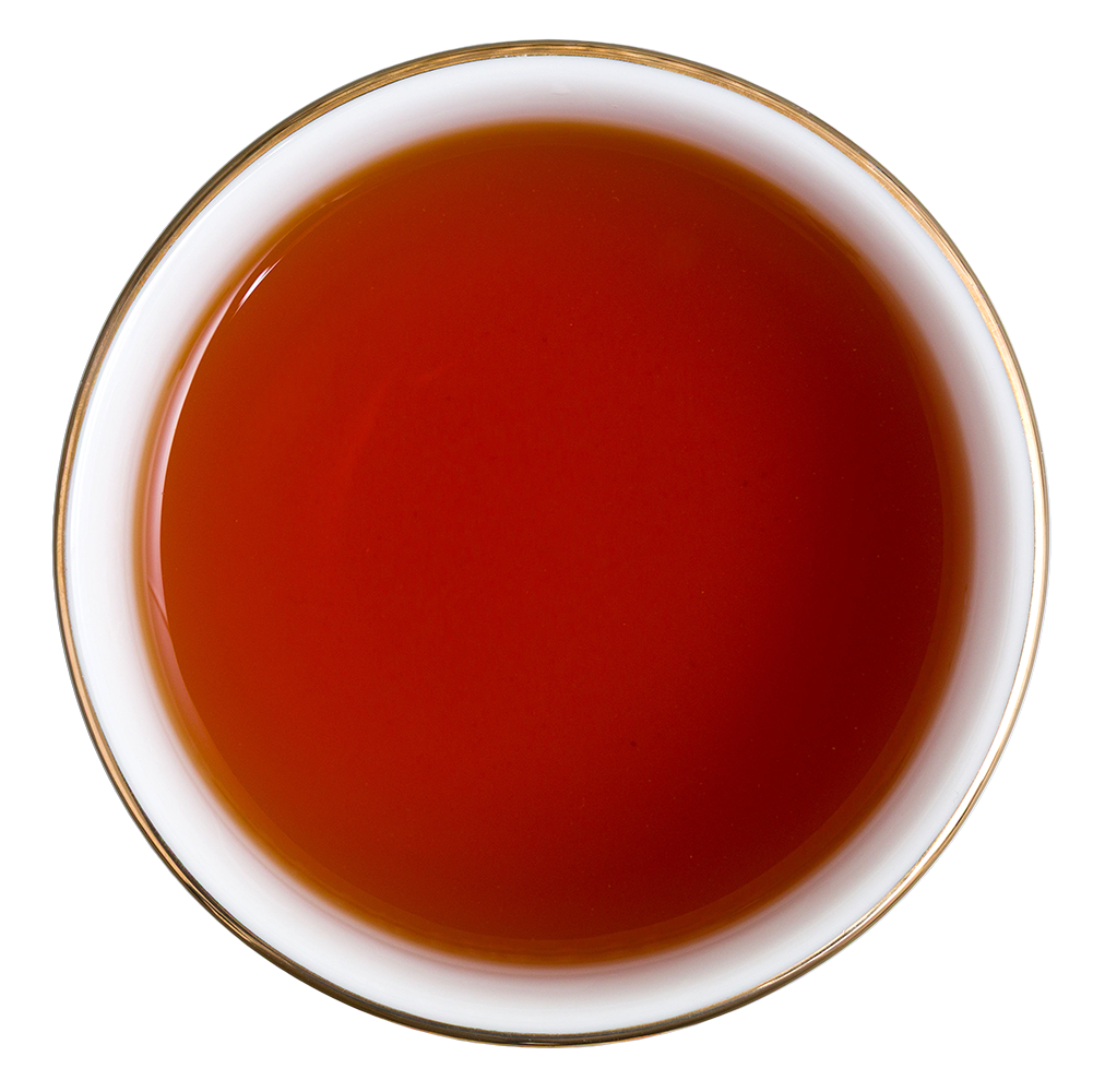 Gotowy napar Basilur Rooibos w filiżance, herbata rooibos o intensywnej bursztynowo-czerwonej barwie.