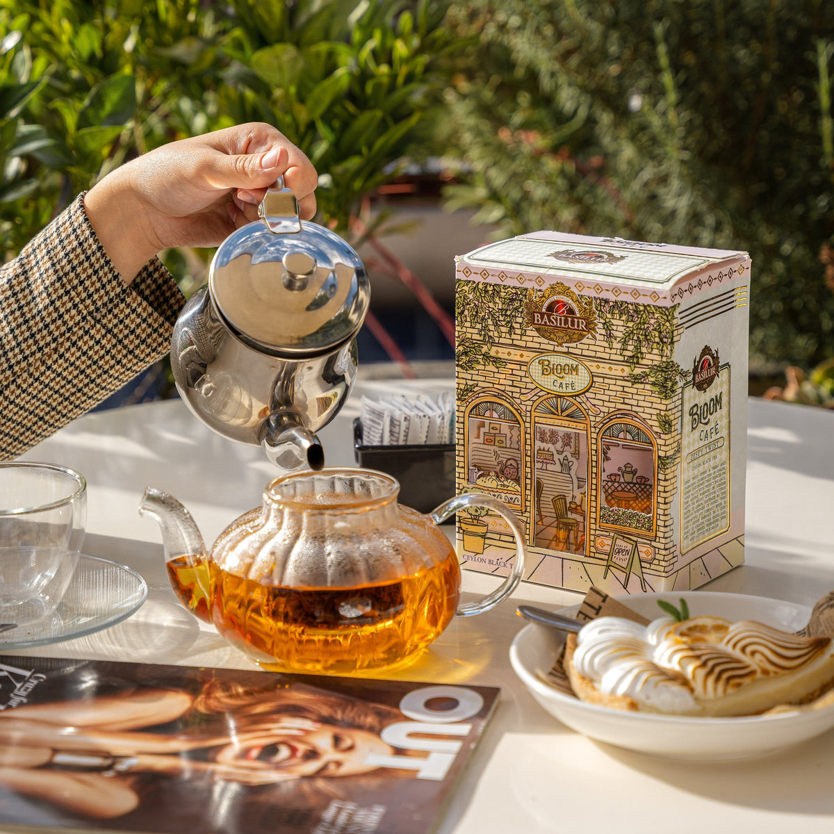 Herbata Basilur Bloom Cafe Zesty Twist na stoliku obok szklanego dzbanka z naparem i deseru