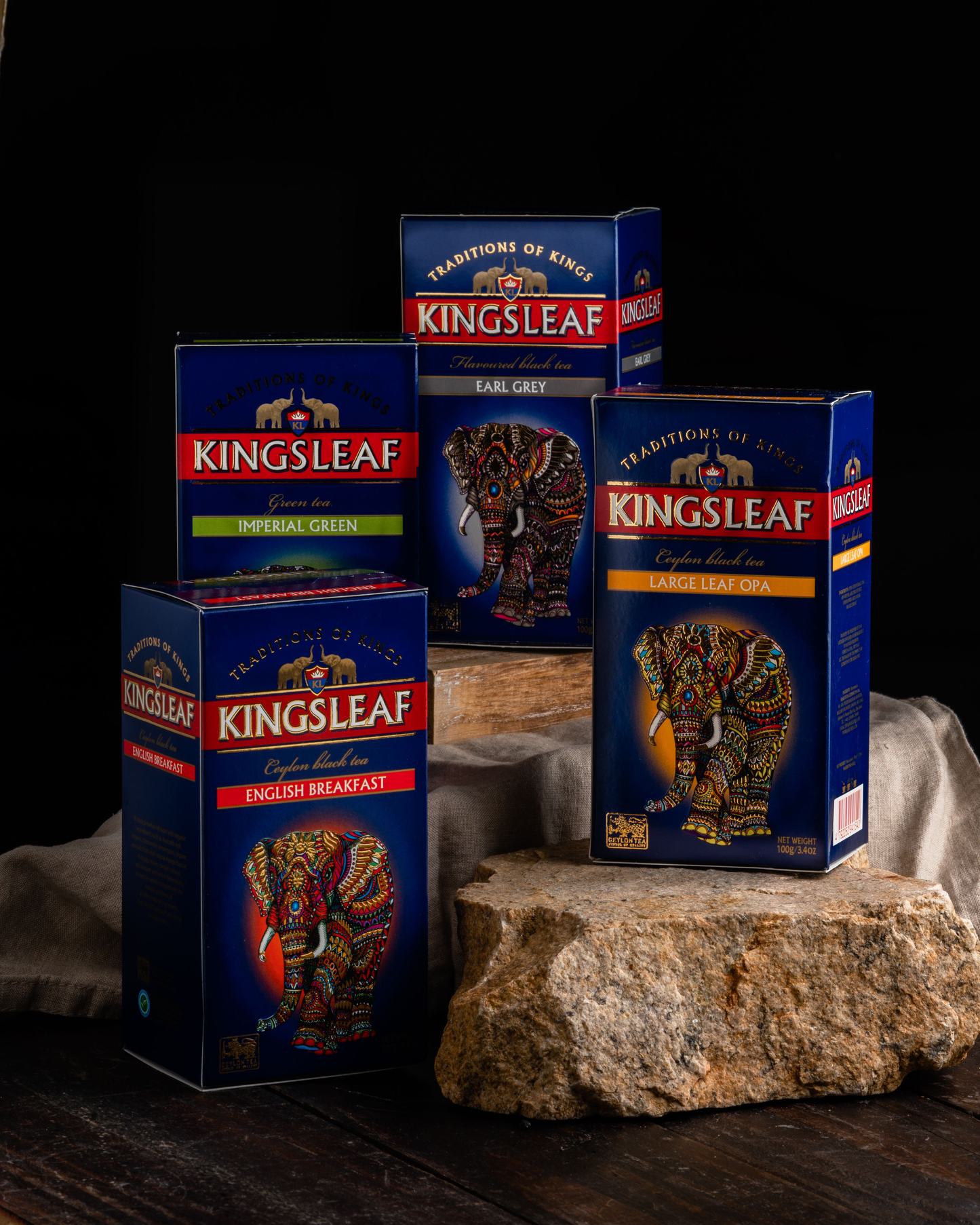 Zestaw różnych herbat Kingsleaf, w tym English Breakfast, na ciemnym tle.