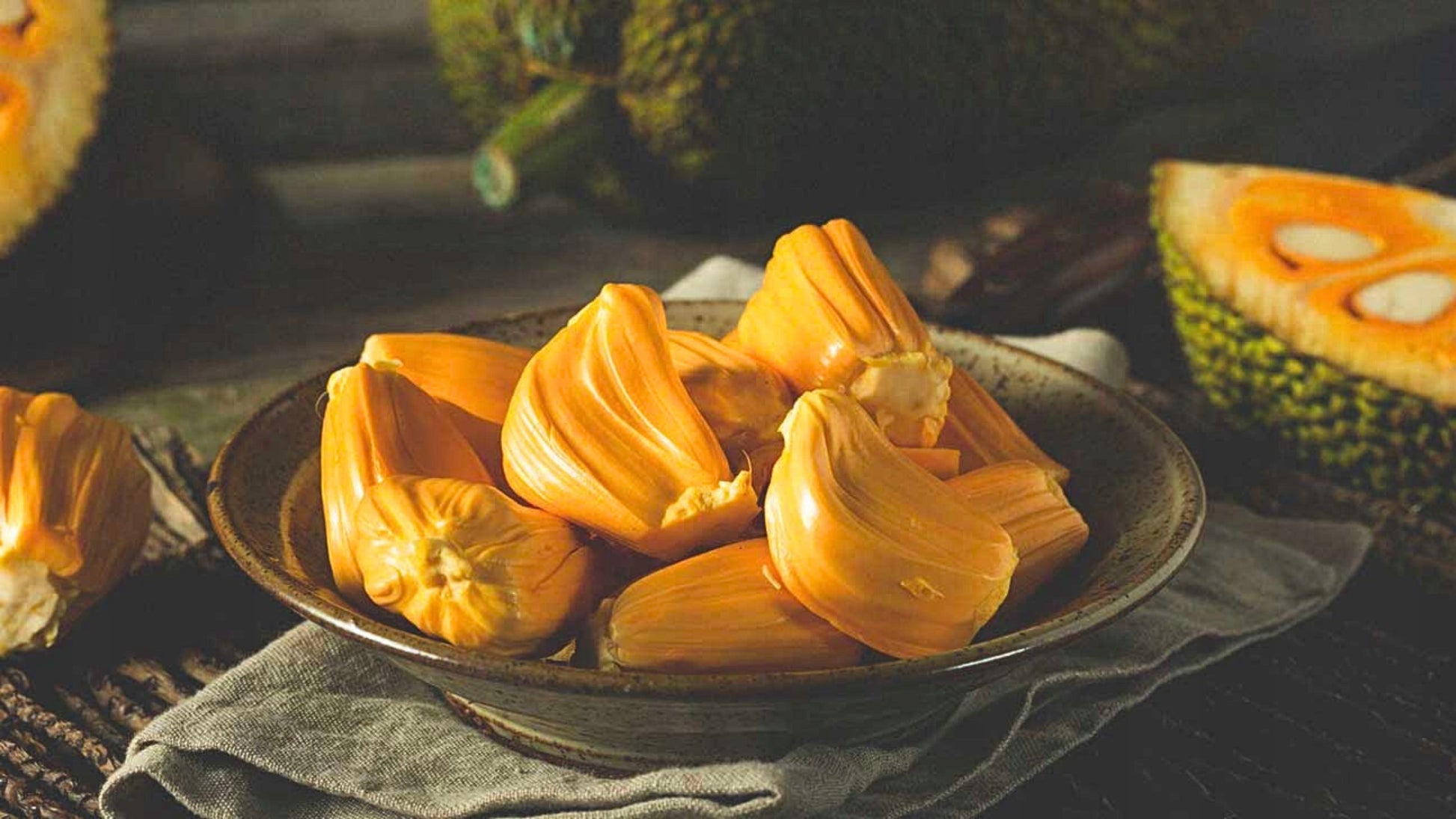 Kawalki dojrzalego jackfruit na talerzu, soczysty chlebowiec o intensywnie zoltym kolorze, egzotyczny owoc tropikalny