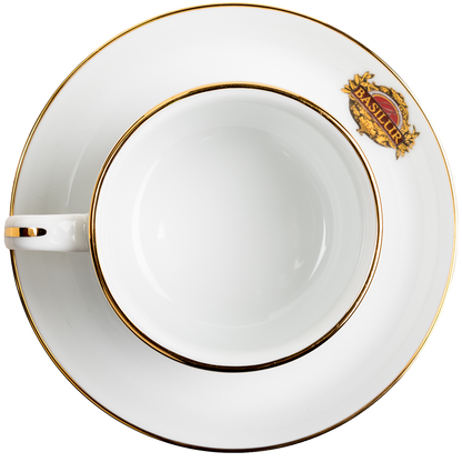 Widok z góry na filiżankę porcelanową Basilur ze spodkiem i złotym rantem.