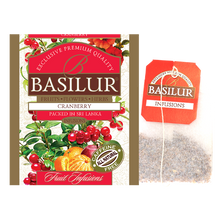 Saszetka herbaty Basilur Cranberry oraz torebka z naparem – owocowa herbata bez kofeiny.